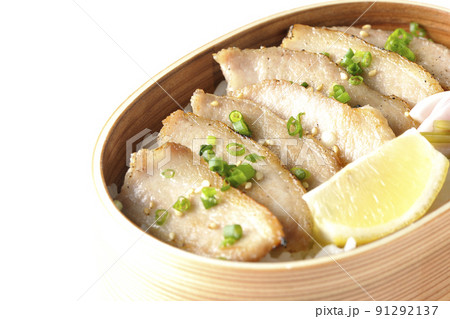 曲げわっぱに漬物とカットレモンと豚トロが入っている焼肉弁当を白背景で撮影 91292137