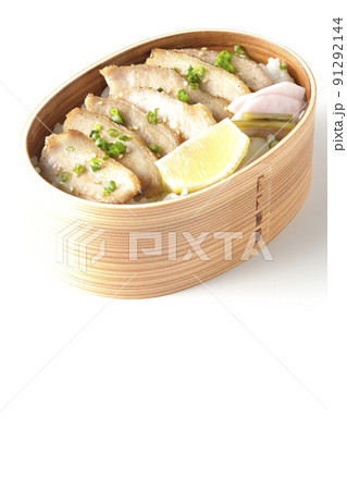 曲げわっぱに漬物とカットレモンと豚トロが入っている焼肉弁当を白背景で撮影 91292144