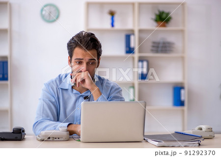 Young male call center operator working at his desk 91292370