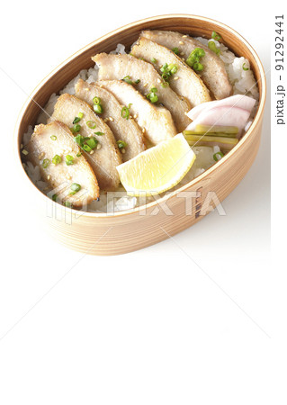曲げわっぱに漬物とカットレモンと豚トロが入っている焼肉弁当を白背景で俯瞰撮影 91292441
