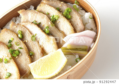 曲げわっぱに漬物とカットレモンと豚トロが入っている焼肉弁当を白背景で俯瞰撮影 91292447