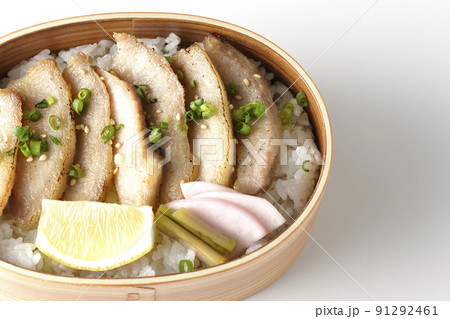 曲げわっぱに漬物とカットレモンと豚トロが入っている焼肉弁当を白背景で俯瞰撮影 91292461