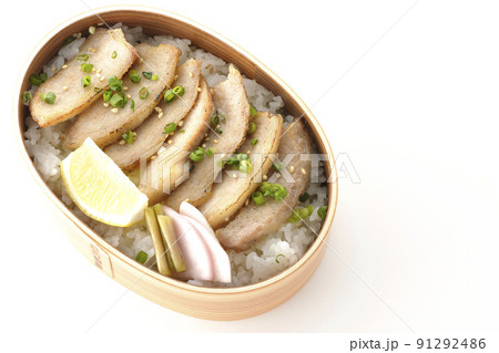 曲げわっぱに漬物とカットレモンと豚トロが入っている焼肉弁当を白背景で俯瞰撮影 91292486