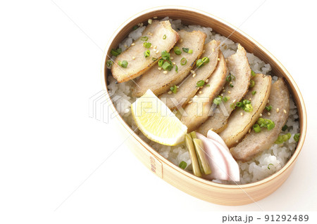 曲げわっぱに漬物とカットレモンと豚トロが入っている焼肉弁当を白背景で俯瞰撮影 91292489