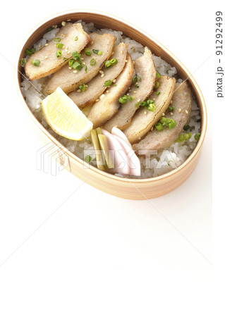 曲げわっぱに漬物とカットレモンと豚トロが入っている焼肉弁当を白背景で俯瞰撮影 91292499