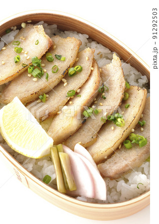 曲げわっぱに漬物とカットレモンと豚トロが入っている焼肉弁当を白背景で俯瞰撮影 91292503