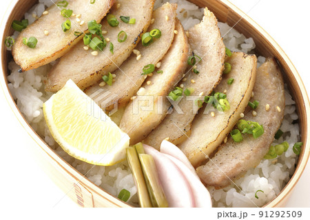 曲げわっぱに漬物とカットレモンと豚トロが入っている焼肉弁当を白背景で俯瞰撮影 91292509