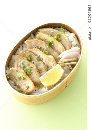 曲げわっぱに漬物とカットレモンと豚トロが入っている焼肉弁当を俯瞰で撮影 91292665