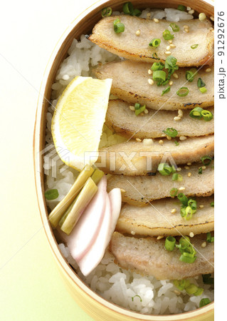 曲げわっぱに漬物とカットレモンと豚トロが入っている焼肉弁当を俯瞰で撮影 91292676