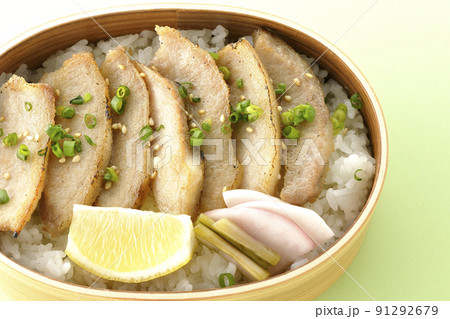 曲げわっぱに漬物とカットレモンと豚トロが入っている焼肉弁当を俯瞰で撮影 91292679