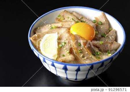 カットレモンと卵黄が乗った豚トロ丼、焼き肉丼を黒背景で撮影 91296571