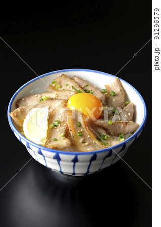 カットレモンと卵黄が乗った豚トロ丼、焼き肉丼を黒背景で撮影 カットレモンと卵黄が乗った豚トロ丼、焼き肉丼を黒背景で撮影 91296579