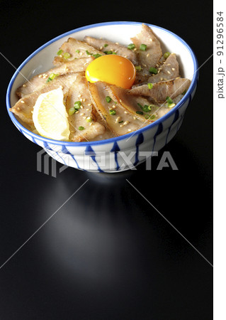 カットレモンと卵黄が乗った豚トロ丼、焼き肉丼を黒背景で撮影 カットレモンと卵黄が乗った豚トロ丼、焼き肉丼を黒背景で撮影 91296584