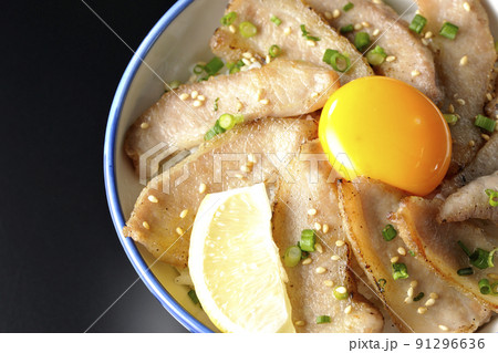 カットレモンと卵黄が乗った豚トロ丼、焼き肉丼を黒背景で俯瞰撮影 カットレモンと卵黄が乗った豚トロ丼、焼き肉丼を黒背景で俯瞰撮影 91296636