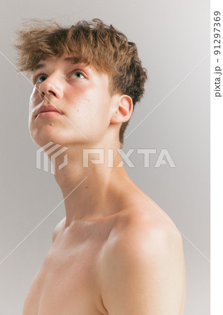 Beauty portrait of young man, teen looking up isolated on grey studio background. Concept of teenage skin care, health, cosmetics for problem skin, youth Beauty portrait of young man, teen looking up isolated on grey studio background. Concept of teenage skin care, health, cosmetics for problem skin, youth 91297369