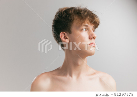 Closeup young man, teen isolated on grey studio background. Concept of teenage skin care, health, cosmetics for problem skin, youth Closeup young man, teen isolated on grey studio background. Concept of teenage skin care, health, cosmetics for problem skin, youth 91297378