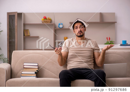 Young male student studying at home during pandemic Young male student studying at home during pandemic 91297686