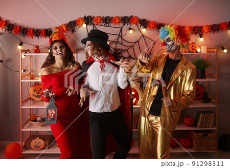 Cheerful friends in spooky costumes have fun together at home party in honor of Halloween. 91298311