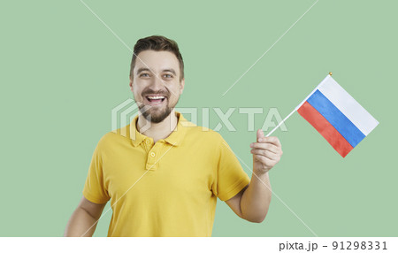 Happy Russian man isolated on green background holding flag of Russian Federation Happy Russian man isolated on green background holding flag of Russian Federation 91298331