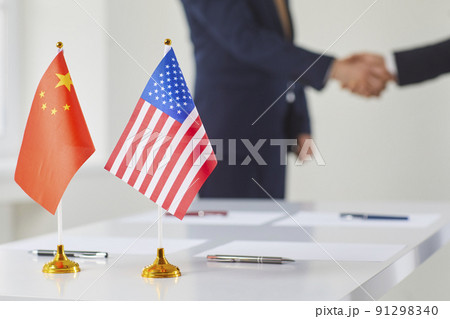 Flags of China and America against background of handshakes of representatives of these countries. 91298340