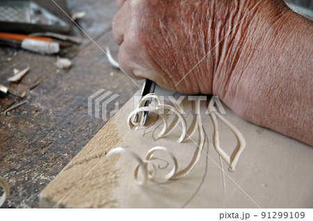 Hands of the craftsman carve a bas-relief in wood 91299109