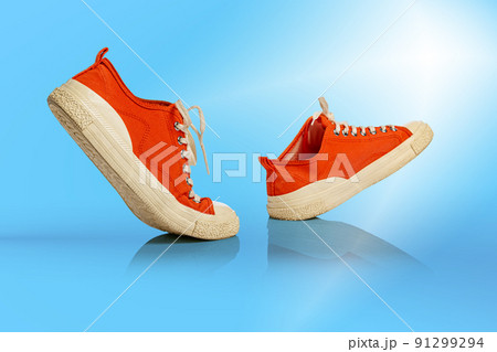 Strolling sports white-orange shoes over blue background. Sneakers or trainers isolated. Athletic shoes. fitness, sport, training concept. Urban fashion 91299294