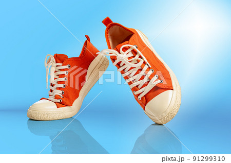 Modern unisex footwear, sneakers isolated on yellow background. Fashionable stylish sports casual shoes. Creative minimalistic layout with footwear. 91299310