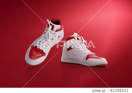Strolling sports shoes on red background. Sneakers or trainers isolated. Athletic shoes. fitness, sport, training concept. Urban fashion 91299321