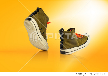 Strolling sports shoes on yellow background. Sneakers or trainers isolated. Athletic shoes. fitness, sport, training concept. Urban fashion 91299323