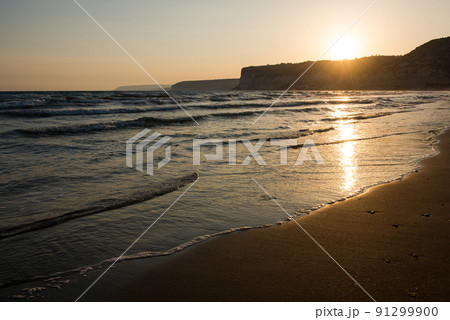Waves approaching sandy beach during the sunset Waves approaching sandy beach during the sunset 91299900