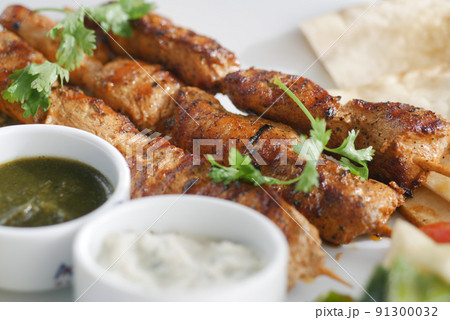 Seekh Kabab, Naan bread, and sauce on a plate  91300032