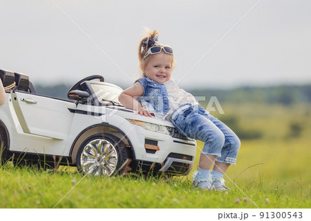 girl standing near her baby car girl standing near her baby car 91300543