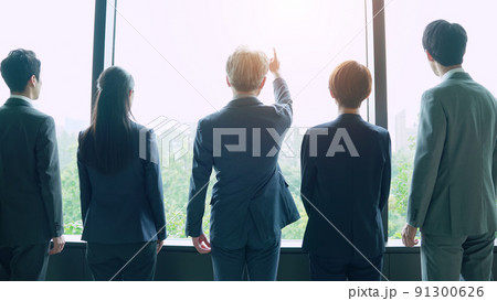 窓から外を眺めるビジネスグループの後ろ姿 91300626