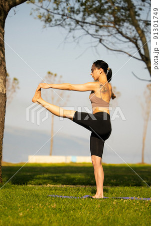 Athletic young woman doing yoga in the Park in the morning. 91301749