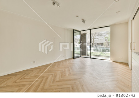 Spacious bright empty room with panoramic windows and parquet floor 91302742