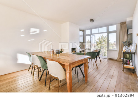 Wooden table with chairs and vase located near drinks rack against light walls and computer desk near the fireplace 91302894