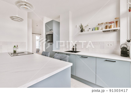 Home interior design of modern loft apartment with open kitchen in minimalist style and spacious dining zone with table and chairs 91303417