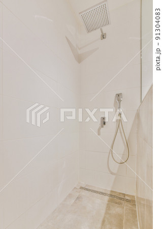Flush toilet located between sink and shower in small tiled bathroom of contemporary apartment Flush toilet located between sink and shower in small tiled bathroom of contemporary apartment 91304083