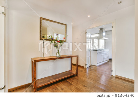 Vintage corridor decorations and mirror located near open kitchen door 91304240