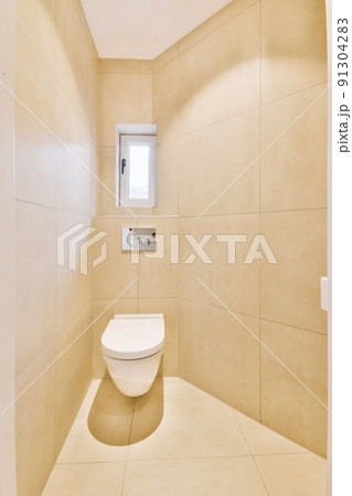 Interior of narrow restroom with sink and wall hung toilet with white walls and checkered floor Interior of narrow restroom with sink and wall hung toilet with white walls and checkered floor 91304283