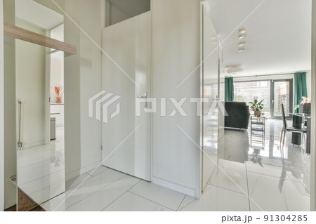 A spacious bright corridor with tiled floor and an entrance to the dining room with a window A spacious bright corridor with tiled floor and an entrance to the dining room with a window 91304285