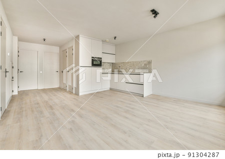 An empty bright room with a window and a minimalistic stylish kitchen corner An empty bright room with a window and a minimalistic stylish kitchen corner 91304287
