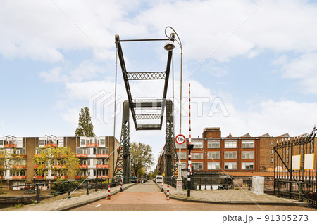 Panorama view of brick houses from an empty sidewalk street with cars, trees and lanterns Panorama view of brick houses from an empty sidewalk street with cars, trees and lanterns 91305273