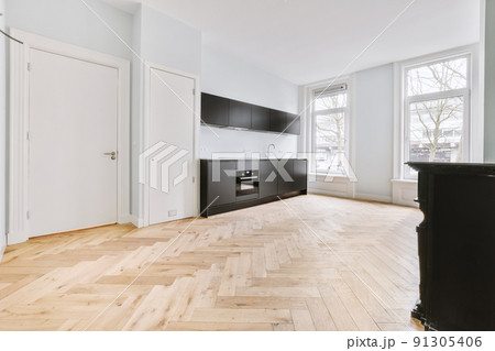 Interior of spacious light room with electric fireplace and elegant chandelier against windows Interior of spacious light room with electric fireplace and elegant chandelier against windows 91305406