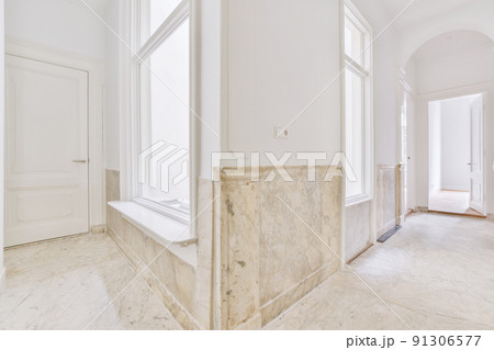 Interior of modern flat in minimal style with narrow empty corridor illuminated by lamps 91306577