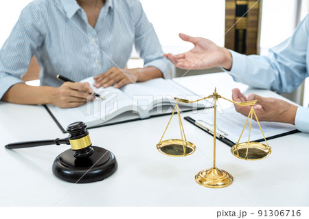 Male lawyer or notary consulting and discussion to businesswoman client in the office, Judge gavel with scales of justice 91306716