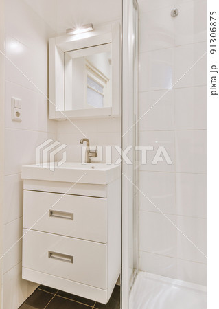 Sink and mirror, next to the shower stall in a modern bathroom with white tiled walls Sink and mirror, next to the shower stall in a modern bathroom with white tiled walls 91306875