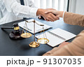 Businesswoman shaking hands with Professional male lawyer after discussing a good deal of contract in the courtroom, Concepts of law, Judge gavel with scales of justice 91307035