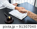 Businesswoman shaking hands with Professional male lawyer after discussing a good deal of contract in the courtroom, Concepts of law, Judge gavel with scales of justice 91307040