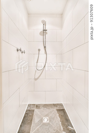 Lovely design of the shower cabin with white tiles and a convenient faucet 91307609